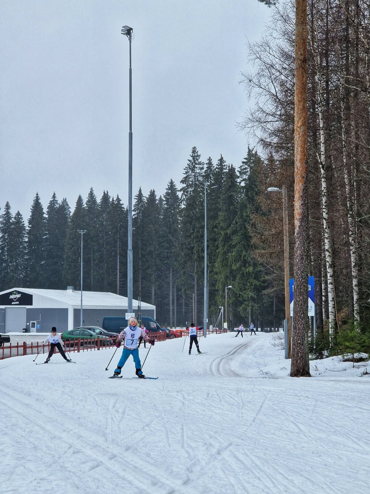 Children skiing towards the camera on a groomed winter track