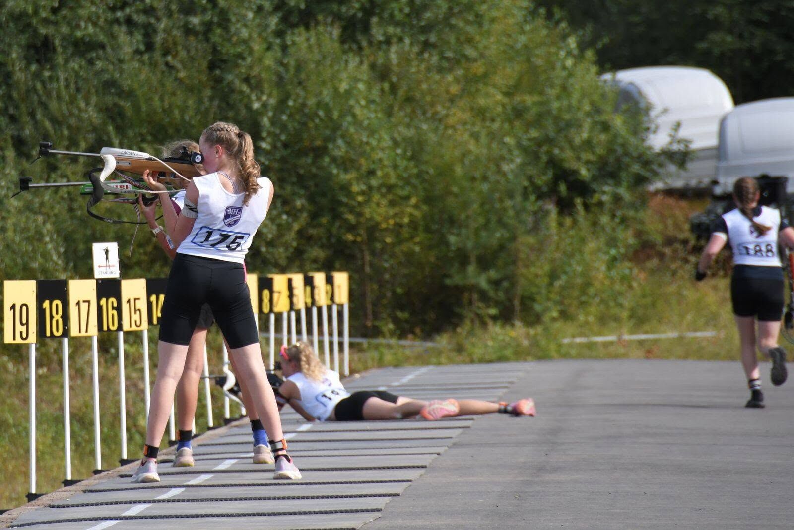 Young athlete shooting standing at a summer biathlon range